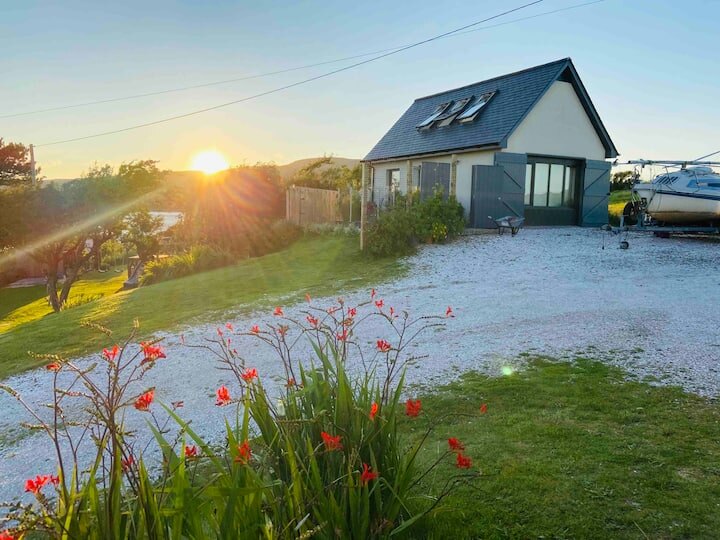 The Boat House in its garden at sunset