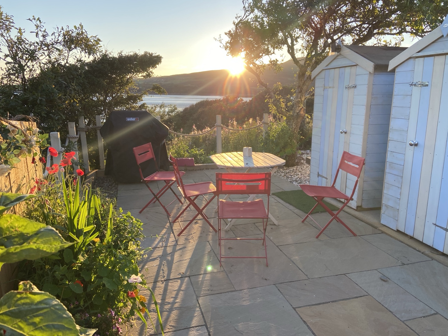 The Boat House patio and beach huts at sunset