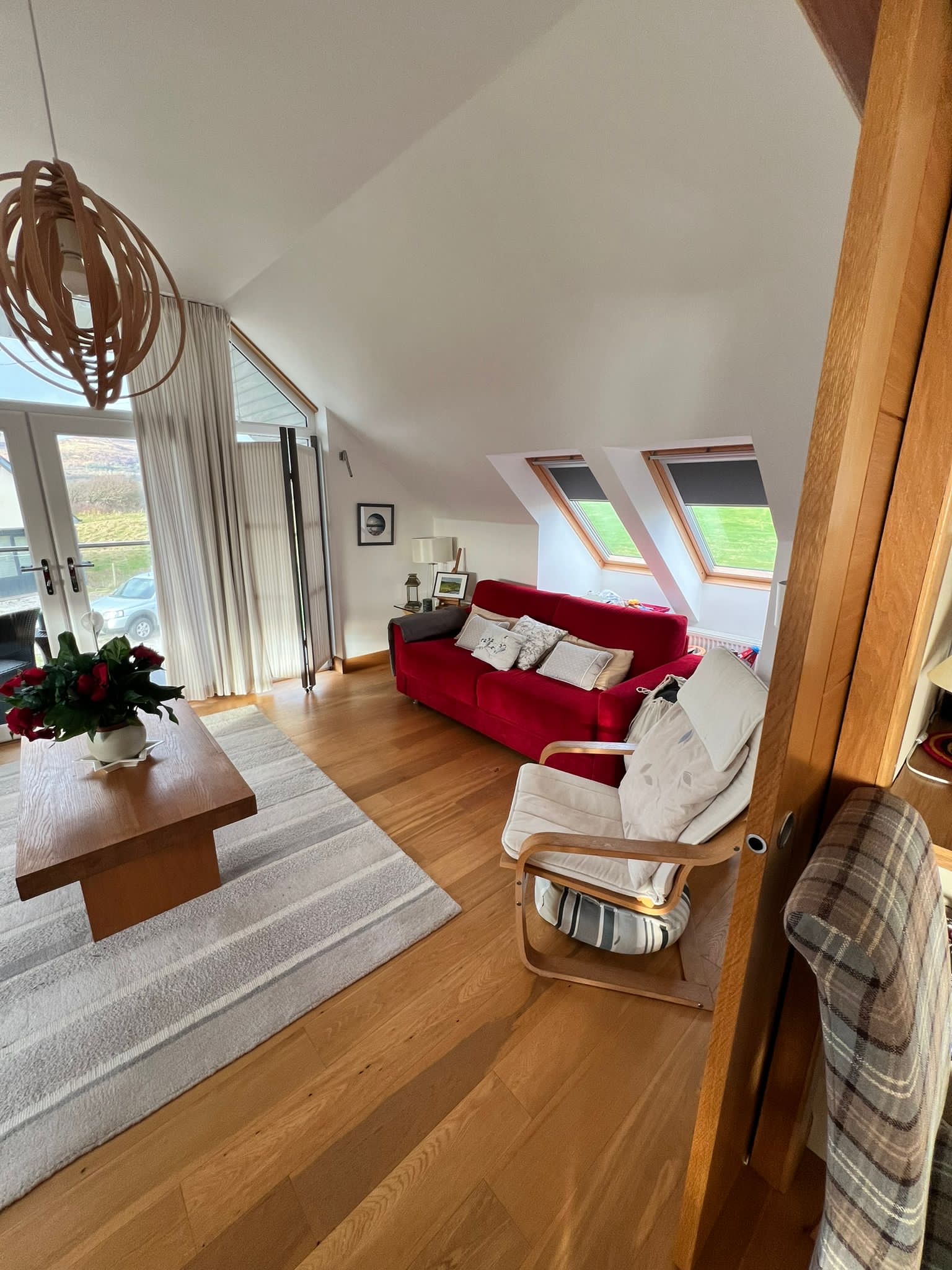 The Sunset Loft's spacious second living room with comfortable seating and doors opening onto the balcony