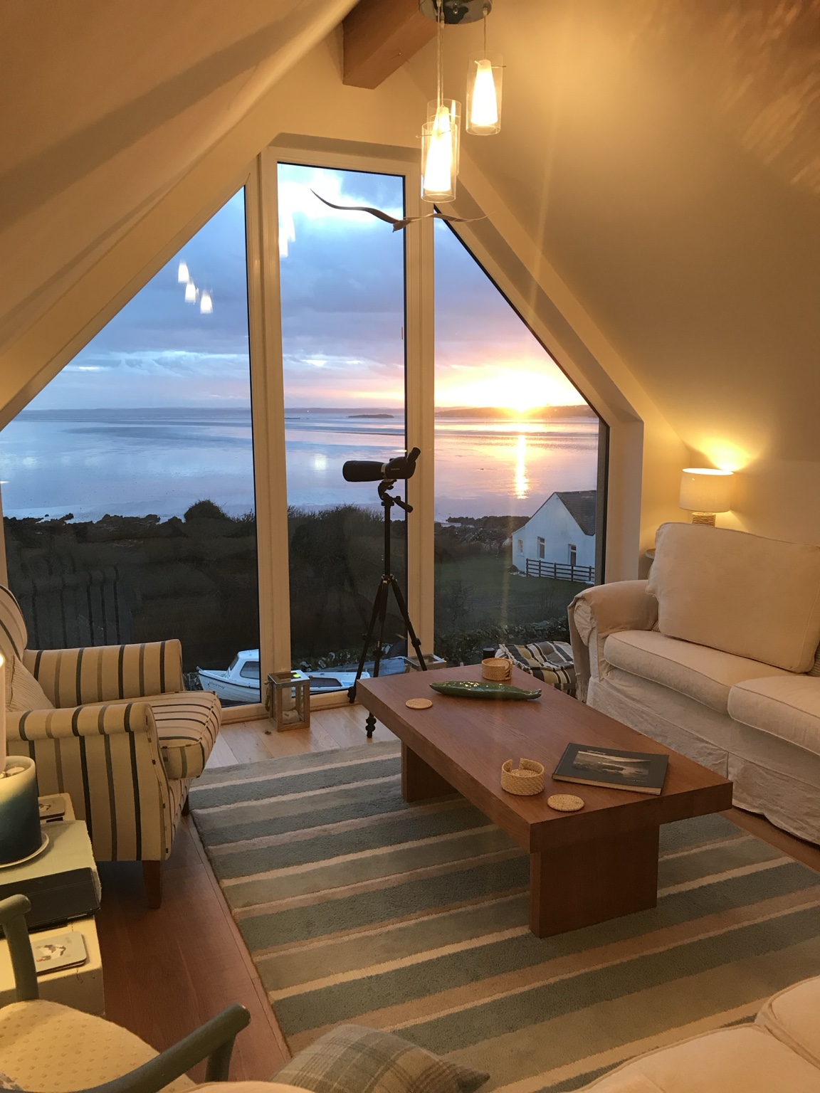 The Sunset Loft sitting room overlooking Fleet Bay at sunset
